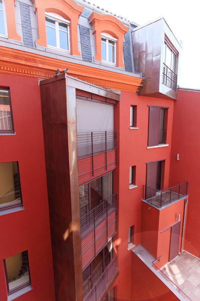 Les façades donnant sur la cour ont été repeintes en rouge, les corniches en oranges, et de grandes fenêtres ont été installé : le Grand Hôtel de Toulouse connaît un réel renouveau, entre modernité et originalité.