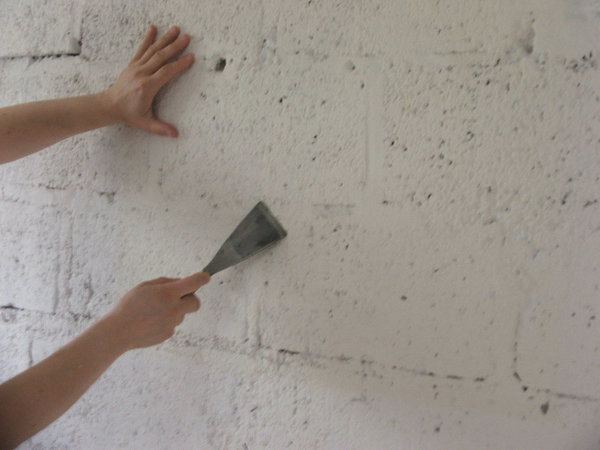 Etape 3 : Egrenez l’ensemble du mur, dans le but d’enlever toutes les aspérités rugueuses, aidez-vous pour cela d’un riflard de maçon à la lame rigide.