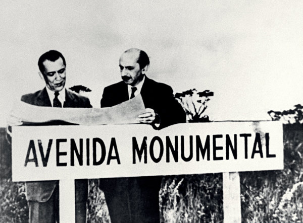 Le président brésilien Juscelino Kubitschek, et l’urbaniste Lucio Costa, au point zéro de la construction de l’Avenue Monumentale, qui coupe la ville en deux parties symétriques. Cette avenue est considérée par les brésiliens comme la plus large du monde.