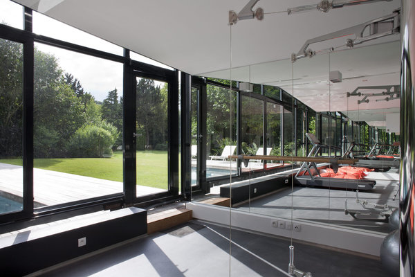 La salle de sport est équipée d’une verrière mobile qui avance au niveau du bassin pour nager hiver comme été.