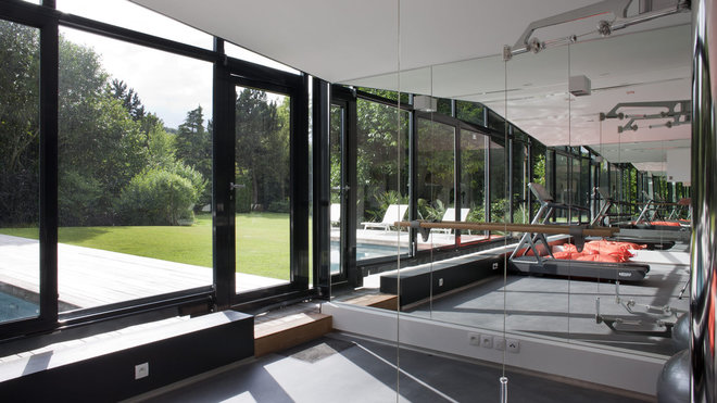 La salle de sport est équipée d’une verrière mobile qui avance au niveau du bassin pour nager hiver comme été.