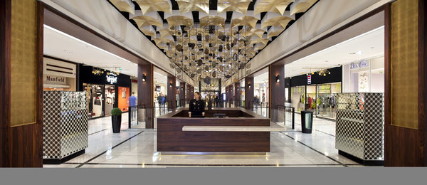 Le plafond, graphique et doré à la feuille de cuivre, donne l’impression d’entrer dans la nef d’une cathédrale, version sixties, en trois dimensions. Place au luxe, à l’image des matériaux utilisés, tels que le marbre blanc de paros et l’acajou laqué.