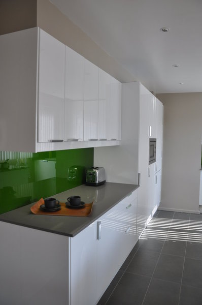 Le sol de la cuisine en grès cérame et le faux plafond intégrant un système d’éclairage délimitent le volume de la cuisine.