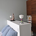 La seconde chambre, le recto de la tête de lit cache un petit bureau. Le rangement bicolore (Cinna) est une composition qui associe placards fermés et niches ouvertes pour le rangement des livres et des CD.