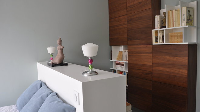 La seconde chambre, le recto de la tête de lit cache un petit bureau. Le rangement bicolore (Cinna) est une composition qui associe placards fermés et niches ouvertes pour le rangement des livres et des CD.