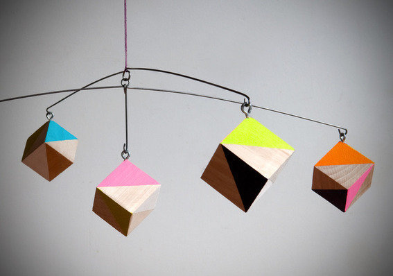 Un mobile en cubes de bois aux couleurs et formes géométriques.