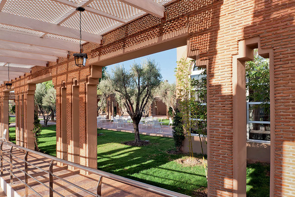 Brique rose, moucharabieh et zelliges omniprésents rendent l'architecture de l'hôtel typiquement marocaine.