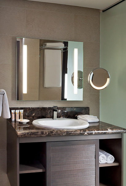 La décoration des chambres est contemporaine. Le marbre et le bois de cèdre sont mis à l’honneur dans cette salle de bains, aux tons taupe et vert clair.