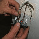 Etape 6 : Enfoncez le premier fil navette dans son logement, et vérifiez bien que le bout de chaque fil soit bien dénudé.