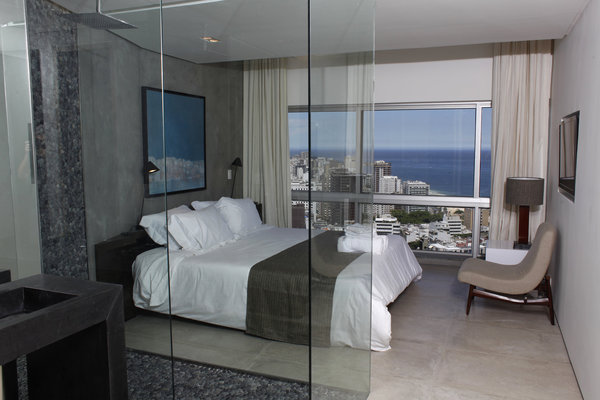 Dans cette autre suite, la vasque de la salle de bains, en granit noir texturé, s’associe à un revêtement en galets à la teinte proche.