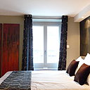 A la tête de lit, un papier peint imitant la peau de vache (Elitis), et un panneau en médium argenté.