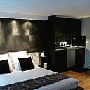 La cuisine se fond dans le décor avec élégance, grâce à une harmonie de teintes neutres, où le noir et le métal dominent. Sur les murs, peintures Ressource et Mise en Teinte.