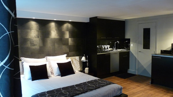 La cuisine se fond dans le décor avec élégance, grâce à une harmonie de teintes neutres, où le noir et le métal dominent. Sur les murs, peintures Ressource et Mise en Teinte.