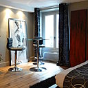 Face au lit, un autre bandeau lumineux intégrant des spots, assure l’éclairage du coin repas, et dessine un effet de symétrie avec celui situé au-dessus de la tête du lit.