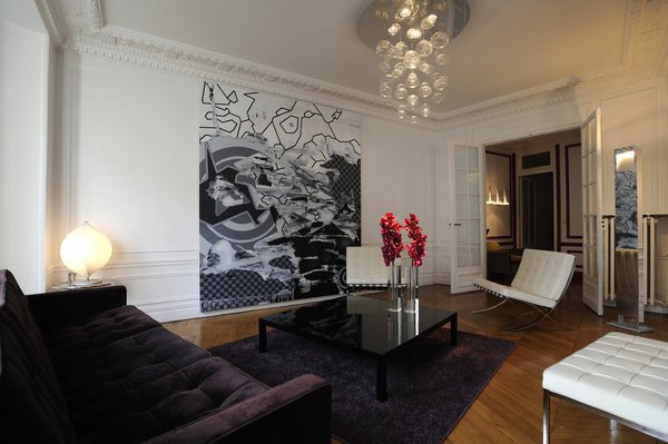 Une attention particulière a été donnée au choix des luminaires. Au salon, une suspension récente et très poétique de Patrick Jouin. En verre de Murano, elle rend la lumière artificielle magique et diffuse des grosses gouttes de lumière.