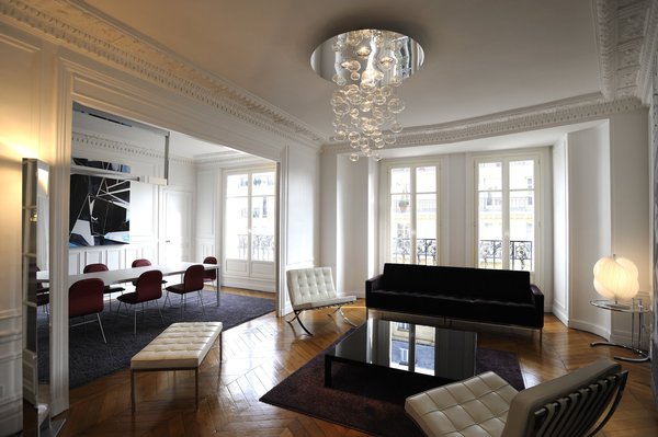 Le double volume typiquement haussmannien des pièces de réception est mis en valeur par le mobilier aux lignes épurées et géométriques.