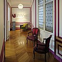 L’entrée, façon couloir, qui dessert toutes les pièces est animée et rendue plus accueillante par un apport de couleur. Les moulures des murs ont été peintes en rouge framboise pour faire oublier leur côté trop classique. Les fauteuils anciens ont été retapissés dans des tissus aux tons vifs.