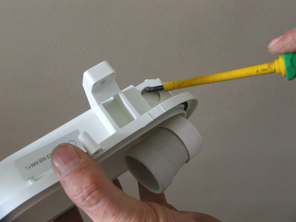 Etape 6 : Préparez la nouvelle applique en retirant les deux capsules sur les côtés gauche et droit, afin de faire passer les fils de connexion électrique.