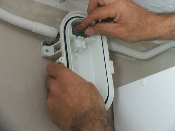 Etape 7 : Positionnez l’applique sur le mur, et faire passer les deux fils (phase et neutre) dans leur logement.