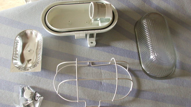 Présentation générale : Support de l’applique avec culot à visser, globe de verre bombé, grille de fixation, panneau réfléchissant, jeux de vis de fixation.