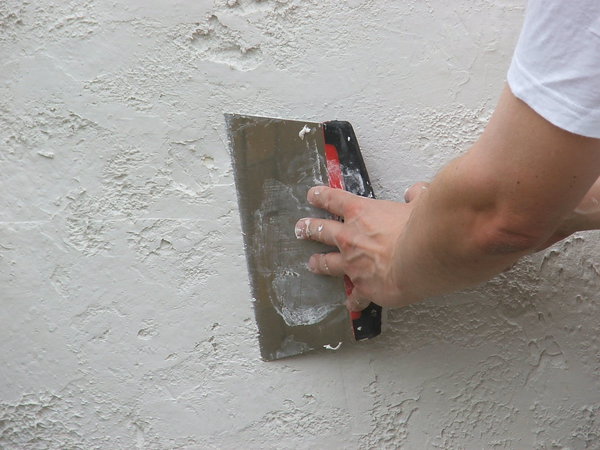 Etape 12 : Revenir avec la lame à enduire sur la partie pochée, afin d’atténuer légèrement le grain de l’enduit.