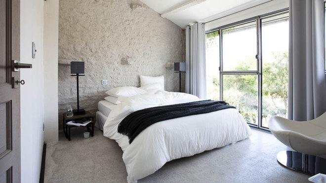 Dans cette chambre blanche du premier niveau, la décoration joue la carte métissée de la rusticité et de la modernité.