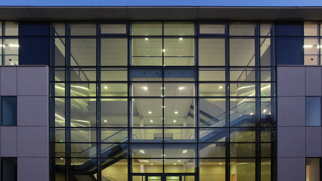 Réponse contemporaine à l’escalier existant conservé, un escalier monumental en béton préfabriqué blanc, doublé d’un ascenseur, dessert le nouveau hall d’entrée.