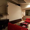 Le salon (fauteuils et canapés, modèle Togo, création Michel  Ducaroy pour Ligne Roset) occupe l’espace central du plateau aménagé sur une base de 200 m². L’escalier mène à la chambre des amis.