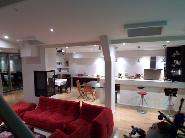 La grande pièce à vivre offre une hauteur de 5 mètres et une largeur de 15 mètres. La disposition du mobilier incite les occupants à se rapprocher du fond, du patio et de la lumière.