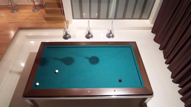 L’emplacement du billard est marqué par un encadrement de marches et un sol revêtu de résine.
