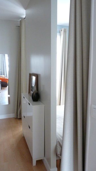 Rien à voir avec l’ancienne chambre. Un nouveau pan de mur cache le lit encadré par deux ouvertures symétriques. De chaque côté, un espace de circulation a été prévu. Il peut être camouflé par des rideaux occultants. Dans le couloir un meuble à chaussures très étroit (Ikea) a pu prendre place.
