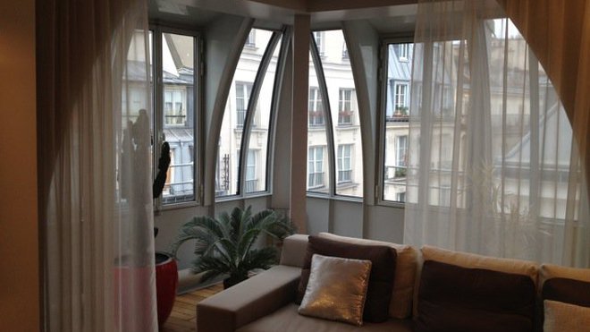 Le bow-window restauré à l’identique offre une jolie vue sur les toits de Paris et un coin salon supplémentaire.
