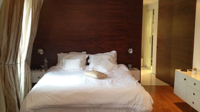 Les fenêtres de la chambre principale sont habillées de lourds rideaux en soie élégants comme une robe d’un autre temps. La tête de lit en Palissandre structure l’espace.