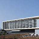 Ce volume en béton blanc avec façade de verre à faible émissivité est en partie protégé par un rideau de forme elliptique en Corian ® noir. Il permet de conserver, à l’intérieur, un cadre visuel maximum, tout en réduisant l’impact solaire. Maison BBC, chauffée par géothermie, équipée de rupteurs thermiques et d’une ventilation à double flux. Creation Au*M [Pierre Minassian], Chipster Blister House, 2012.