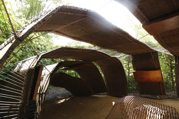 Gram(in)ophone. Structure respirante émergeante du sol, dont la voûte semble érodée, sculptée par les mouvements du vent, et qui offre un espace ouvert à de nouvelles sensations. Au centre de la voûte, un concert  de sonorités. Aux alentours, un champ de graminées. Création Alexandra Epée, Flora rich et Olivier Brichet (France).