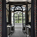 À l’entrée, la belle symétrie des pans de rideaux préserve la confidentialité du restaurant. À l’entrée, la belle symétrie des pans de rideaux préserve la confidentialité du restaurant.