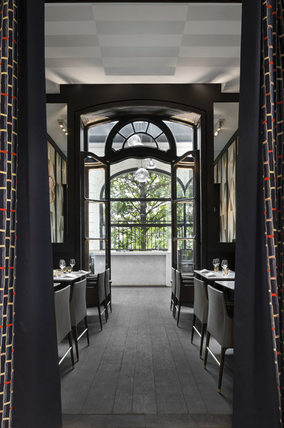 À l’entrée, la belle symétrie des pans de rideaux préserve la confidentialité du restaurant.