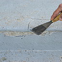 Etape 2 : A l’aide d’un riflard de maçon, éliminer tous les résidus de béton abîmés et non adhérents. Elargir les fissures apparentes ; bien insister avec l’outil.