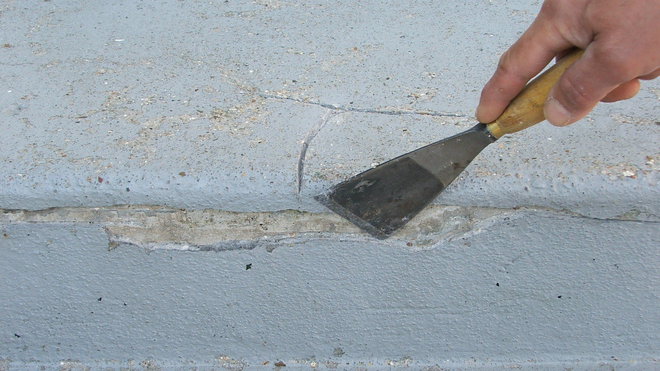 Etape 2 : A l’aide d’un riflard de maçon, éliminer tous les résidus de béton abîmés et non adhérents. Elargir les fissures apparentes ; bien insister avec l’outil.