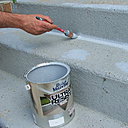 Etape 12 : Appliquer la peinture spéciale pour sols sur tous les angles et les bordures ; bien décharger la brosse de pouce de peinture à chaque passage.