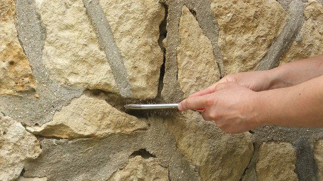 Etape 1 : A la brosse métallique, grattez l’ensemble de la partie endommagée de la pierre ; bien insister sur l’outil, afin d’enlever toutes parties non adhérentes.