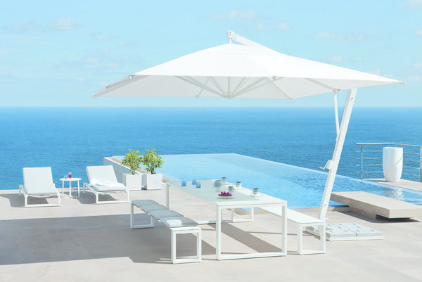 Dans la collection Nautic 2012 de Manutti, on trouve ce bel ensemble de repas, comprenant une table avec un plateau en verre blanc, deux bancs en aluminium thermolaqué, et un parasol carré en toile.