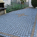 Après: une belle terrasse de pavés de granit avec une étoile contrastée en son centre