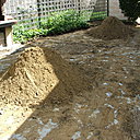 Etape 3 : Sur le terrain prêt à recevoir le pavage, la pose d’un polyane est une option qui pourra se justifier  dans le cas de risque de remontée d'eau par capillarité. Mettre le sable en petit tas sur le terrain. Le sol doit être au préalable décaissé sur 15 ou 22 cm de profondeur.