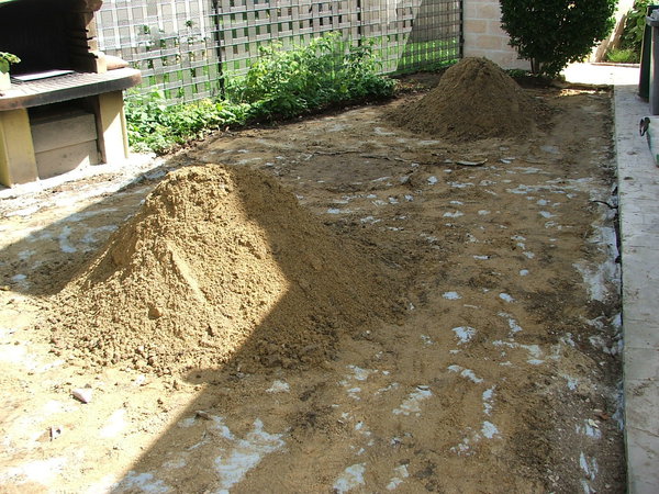 Etape 3 : Sur le terrain prêt à recevoir le pavage, la pose d’un polyane est une option qui pourra se justifier  dans le cas de risque de remontée d'eau par capillarité. Mettre le sable en petit tas sur le terrain. Le sol doit être au préalable décaissé sur 15 ou 22 cm de profondeur.