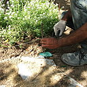 Etape 4 : Délimiter la terrasse avec des piquets plantés à chaque coin et reliés par un cordeau. Cela permettra aussi de donner la hauteur de pose des pavés de granit.