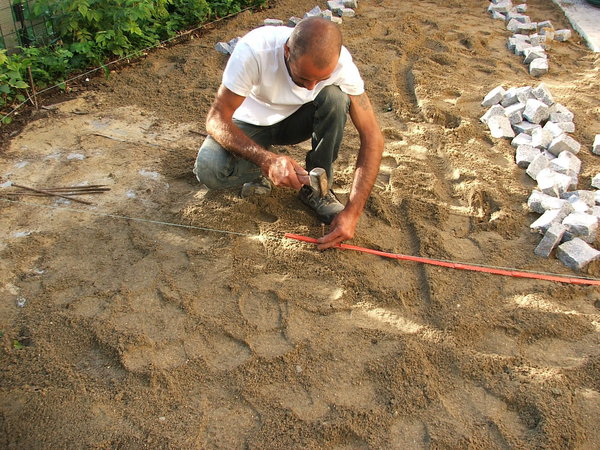 Etape 8 : Pour le positionnement du motif (dans notre cas, il s’agit d’implanter une petite étoile qui sera réalisée en pavés de couleur ocre), chercher le centre de la surface à paver et y planter un piquet.