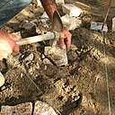 Etape 10 : Le pavé se taille avec un marteau de maçon en le frappant avec précision sur la partie à enlever.