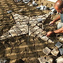Etape 11 : Réaliser le pavage de la petite étoile avec des pavés entiers à l’intérieur de la forme, et avec des pavés taillés sur le pourtour de cette dernière. Il s’agit d’enfoncer les pavés dans le sable cimenté, tout en gardant une hauteur la plus régulière possible entre les pavés de granit.