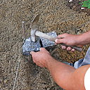 Etape 12 : Débuter la pose à proprement dite dans un angle, en se calant pour la hauteur au niveau du cordeau. Frapper légèrement chaque pavé, afin de bien le caler dans la sable.